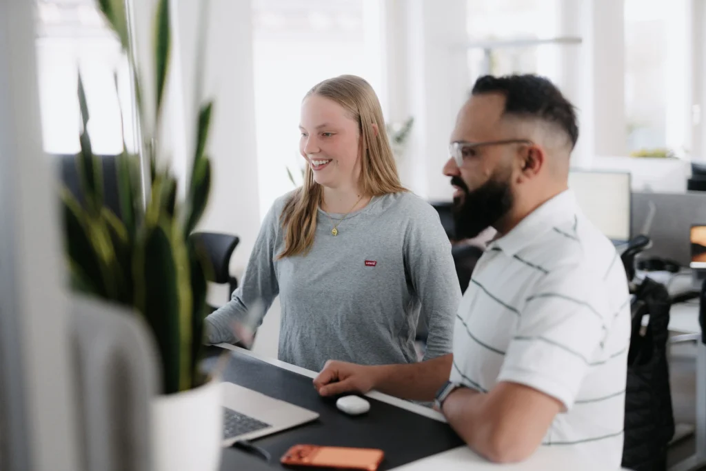 Zwei Teammitglieder von ACCSCALE am Schreibtisch